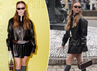 Sydney Sweeney rocks a bold, edgy look featuring a leather miniskirt paired with leg warmers on the catwalk at Paris Fashion Week.